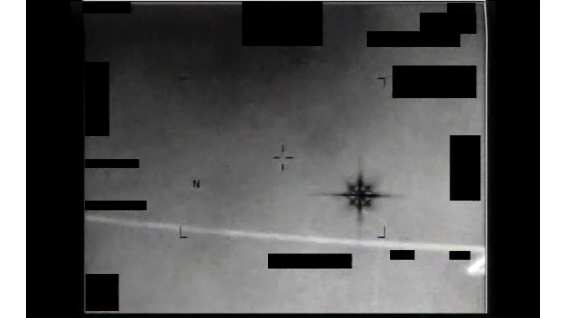 Frame from the declassified DOW-UAP-PR038 infrared video showing the symmetrical eight-pointed 'Chandelier' thermal signature over the Persian Gulf, redaction bars visible around the sensor overlay