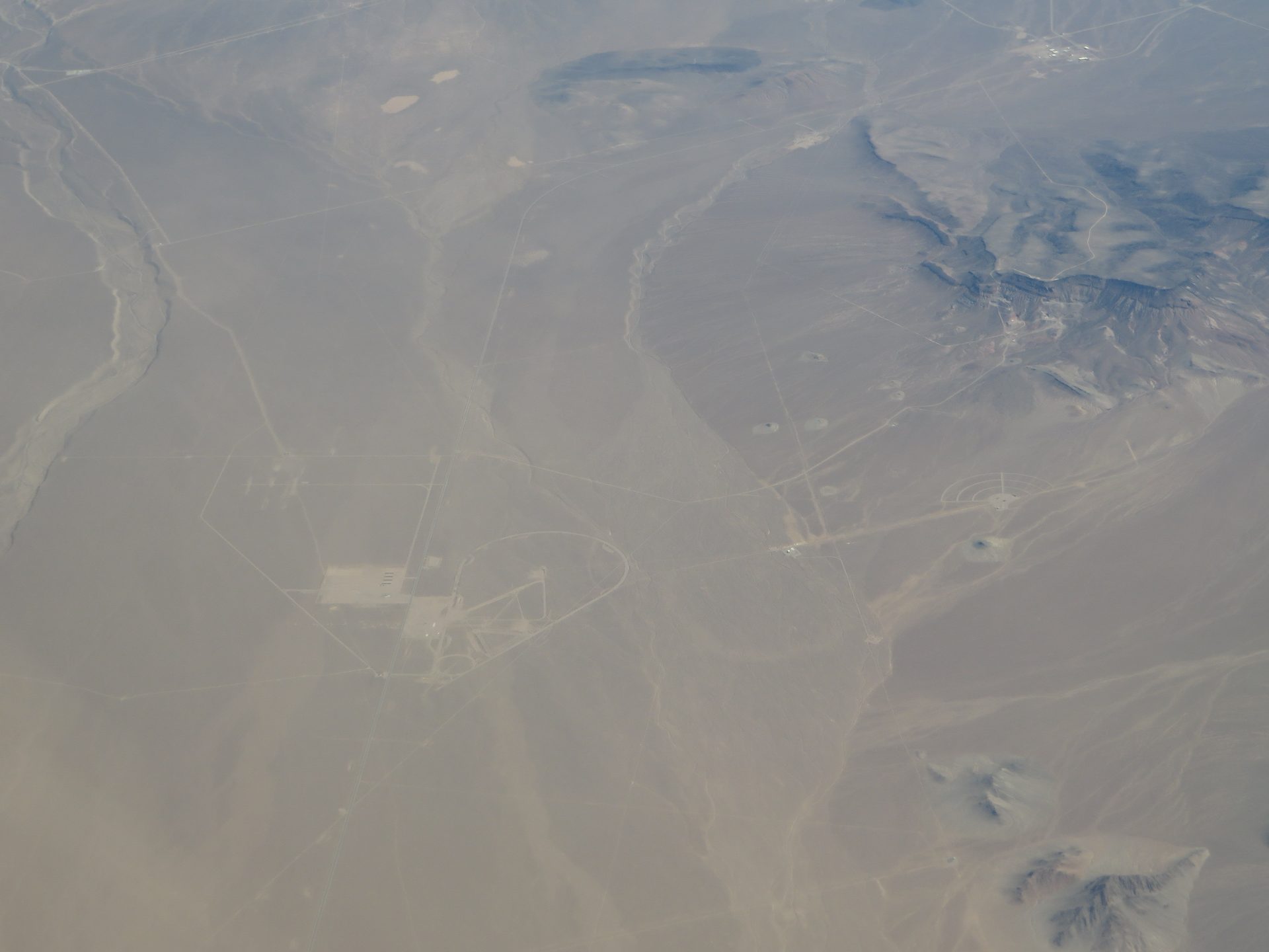 Aerial view of high desert terrain typical of a fenced U.S. Department of Energy national security reservation in the American West, illustrative of the case's redacted setting